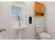 Tastefully designed half-bathroom featuring a pedestal sink and wooden cabinet at 2210 Moraine Ct, Lakeland, FL 33805