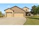 Charming home featuring a stone facade and a three-car garage, complemented by a well-maintained lawn at 2210 Moraine Ct, Lakeland, FL 33805