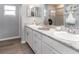 Bright bathroom with a double vanity, granite countertops, framed mirror, and a glass-enclosed shower at 2335 Northumberland Ct, Haines City, FL 33844