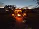 Evening shot of backyard featuring fire pit, benches, brick pathway, gazebo with outdoor seating and a deck with hot tub at 27836 Lois Dr, Tavares, FL 32778