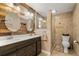 Bathroom featuring wood accent wall, double vanity, oval mirrors, and glass shower at 27836 Lois Dr, Tavares, FL 32778