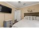 Bedroom featuring a ceiling fan, a mounted television, nautical décor, and neutral paint at 27836 Lois Dr, Tavares, FL 32778