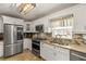 Modern kitchen featuring stainless steel appliances, granite countertops, and white cabinets with a view of pool at 27836 Lois Dr, Tavares, FL 32778