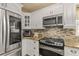 Close-up of a modern kitchen featuring stainless steel appliances and granite countertops, ready for culinary adventures at 27836 Lois Dr, Tavares, FL 32778