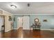 Open living room with dark hardwood floors, light blue accent walls, and a white barn door at 27836 Lois Dr, Tavares, FL 32778