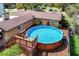 Aerial view of above-ground pool with deck and privacy fence in a well landscaped backyard at 27836 Lois Dr, Tavares, FL 32778