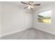 Comfortable bedroom with gray carpet, a fan, and a window at 2924 Bellwood Ave, Lakeland, FL 33803