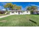 Exterior of home featuring a lush green lawn, freshly painted with bright white accents at 2924 Bellwood Ave, Lakeland, FL 33803