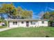 Charming single-story home featuring a well-manicured lawn and neutral-toned exterior with black door at 2924 Bellwood Ave, Lakeland, FL 33803