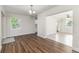 Open-concept living space with wood floors, white walls, a modern light fixture, and connecting rooms at 2924 Bellwood Ave, Lakeland, FL 33803