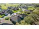 An aerial view showcases a quiet residential street with well-manicured lawns and diverse home exteriors under a sunny sky at 2987 Mission Lakes Dr # 10, Lakeland, FL 33803