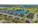 An aerial view displays a community with a tranquil lake featuring a fountain, surrounded by colorful homes and green spaces at 2987 Mission Lakes Dr # 10, Lakeland, FL 33803