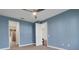 Blue Bedroom featuring ceiling fan, doors to other rooms and carpeted floors at 2987 Mission Lakes Dr # 10, Lakeland, FL 33803