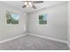 Bright bedroom featuring plush gray carpeting and a ceiling fan with overhead lighting at 300 Senate St, Auburndale, FL 33823