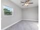 Bedroom with gray carpet, ceiling fan and a large window providing natural light at 300 Senate St, Auburndale, FL 33823