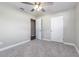 Neutrally decorated bedroom with gray carpet, a modern ceiling fan, and built-in closet at 300 Senate St, Auburndale, FL 33823