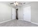 Bedroom with neutral walls, gray carpet, and open closet, complemented by a modern ceiling fan at 300 Senate St, Auburndale, FL 33823