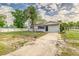 Single-story home with a concrete driveway and a gated front yard, featuring a manicured lawn at 300 Senate St, Auburndale, FL 33823