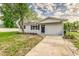 Clean, white home with a tidy lawn, paved walkway, and dark shutters at 300 Senate St, Auburndale, FL 33823