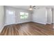 Spacious living room features wood floors, large window and modern ceiling fan at 300 Senate St, Auburndale, FL 33823