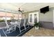 Enclosed lanai featuring dining table, chairs, overhead fan, TV, and brick-paved flooring at 3001 Plantation Rd, Winter Haven, FL 33884