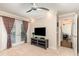 Bright living room features a ceiling fan, television, shelving, and direct access to the outdoor living space at 3001 Plantation Rd, Winter Haven, FL 33884