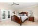 Main bedroom features wood furniture, a ceiling fan, and French door access to a screened in patio at 3001 Plantation Rd, Winter Haven, FL 33884