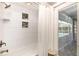 Modern shower with white tiling, shelving niche, shower curtain, and views of the pool at 3001 Plantation Rd, Winter Haven, FL 33884