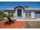 Charming single-story home featuring a front door with sidelights, surrounded by manicured landscaping and a modern color scheme at 3166 Valley Vista Cir, Lakeland, FL 33812