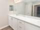 Bathroom featuring double sinks, white cabinets, and a large countertop at 3198 Laurel Oak Ln, Winter Haven, FL 33884