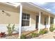 Inviting front porch with white columns, brick accents, neutral paint colors, and decorative landscaping at 3626 Amber Ln, Lakeland, FL 33812