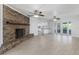 Open-concept living room with brick fireplace, ceiling fans and views of the kitchen at 4120 Old Colony Rd, Mulberry, FL 33860