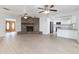 Open-concept living room with brick fireplace, ceiling fans and views of the kitchen at 4120 Old Colony Rd, Mulberry, FL 33860