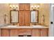 Bathroom featuring dual sinks with marble countertops, stylish lighting, and ample cabinet space at 4759 Lathloa Loop, Lakeland, FL 33811