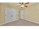 Comfortable bedroom featuring ample closet space, carpet flooring, and a ceiling fan at 4759 Lathloa Loop, Lakeland, FL 33811