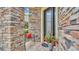 Close-up of an inviting home entrance with a stone facade, decorative bench, and colorful potted flowers at 4759 Lathloa Loop, Lakeland, FL 33811