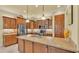 Bright kitchen with an island, wooden cabinetry, modern appliances, and a decorative pendant light at 4759 Lathloa Loop, Lakeland, FL 33811