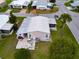 Aerial view of a charming single-story home with a metal roof, patio seating, and lush landscaping at 4985 Deerwood Dr, Lakeland, FL 33810