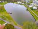 An aerial perspective showcasing the community lake with a fountain, a nearby pier, and walking paths at 4985 Deerwood Dr, Lakeland, FL 33810