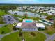 An elevated view of the community pool, clubhouse, tennis courts, parking, landscaping, and surrounding lake at 4985 Deerwood Dr, Lakeland, FL 33810