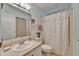 Bright full bathroom features a floral shower curtain, toilet, vanity with a sink, and vanity mirror at 4985 Deerwood Dr, Lakeland, FL 33810