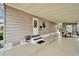 Covered carport featuring an exterior door, space for seating, and views of the landscaped yard at 4985 Deerwood Dr, Lakeland, FL 33810