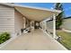 Covered carport featuring an exterior door, space for seating, and views of the landscaped yard at 4985 Deerwood Dr, Lakeland, FL 33810