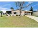 Charming single-story home with a well-manicured lawn, a carport, and a screened in porch at 4985 Deerwood Dr, Lakeland, FL 33810