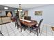 Formal dining room with traditional dark wood table and six chairs under elegant lighting at 5051 Ironwood Trl, Bartow, FL 33830