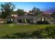 Charming single-story home with a well-manicured lawn and mature trees at dusk at 5051 Ironwood Trl, Bartow, FL 33830