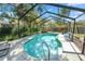 Beautiful screened-in pool with sparkling water, a waterfall feature, and a spacious deck area at 5051 Ironwood Trl, Bartow, FL 33830