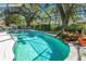 Inviting pool with a rock waterfall feature and a covered screened enclosure with privacy at 5051 Ironwood Trl, Bartow, FL 33830