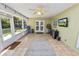 Enclosed sunroom featuring tile floors, ceiling fan, and wall-mounted television at 5051 Ironwood Trl, Bartow, FL 33830