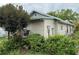 View of the side of the house featuring a small porch surrounded by dense greenery at 5636 Old Highway 37, Lakeland, FL 33811